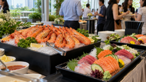 Cooked chilled prawns on ice alongside salmon and tuna sashimi at a Singapore event seafood station