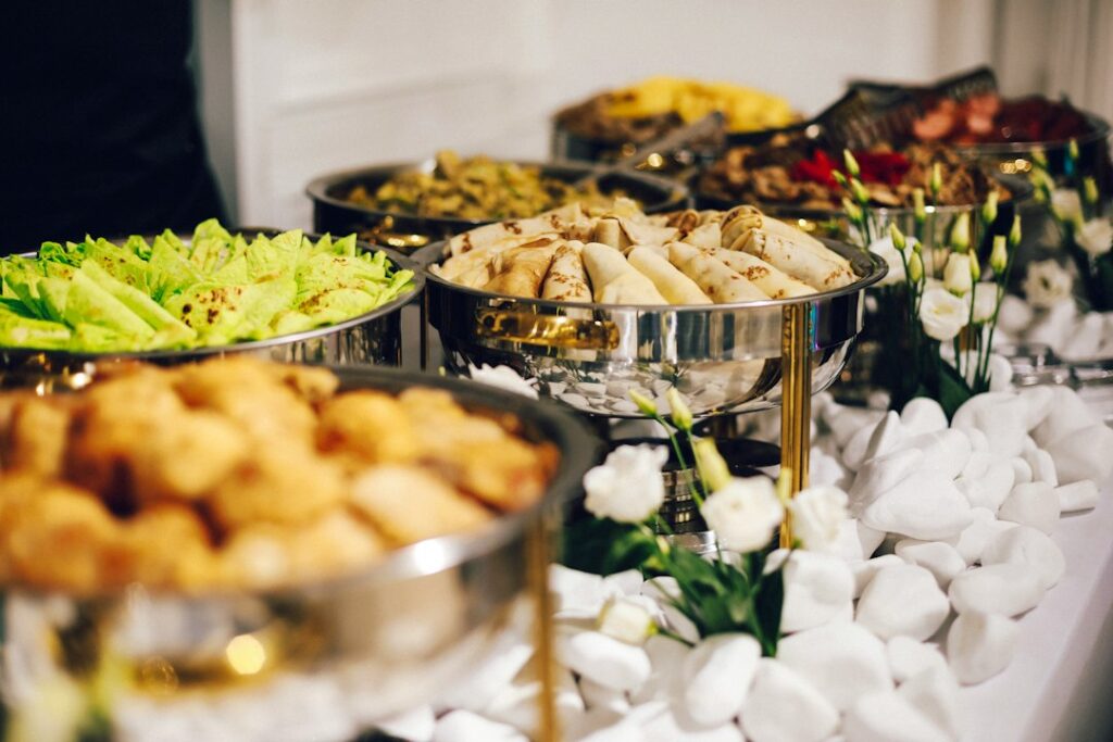 Illustrative buffet catering setup with covered chafing dishes for a Singapore gathering