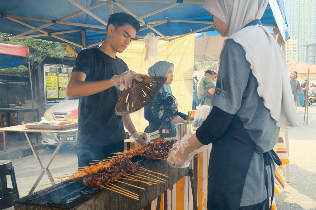 Satay skewers grilled outdoors over charcoal at a street food station