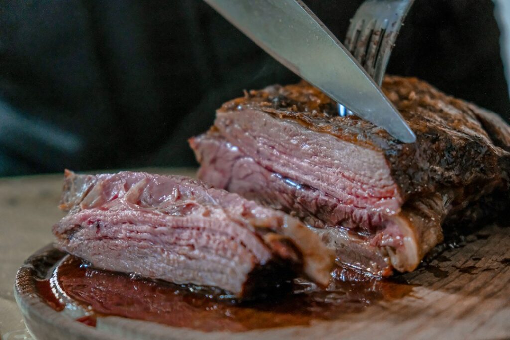 Sliced roast beef being prepared for serving, illustrating safe reheating of Christmas roasts